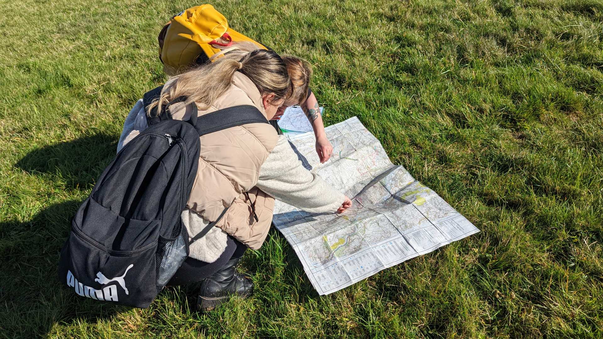 Checking our grid references on an opened-up paper map while out on the annual training walk.