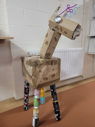 A giraffe made from cardboard and used drinks cans, built for global recycling day.