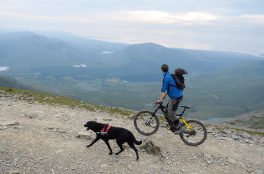 A mountain biker enjoys the far-reaching views from an easier stretch of the ascent up Llanberis Path.