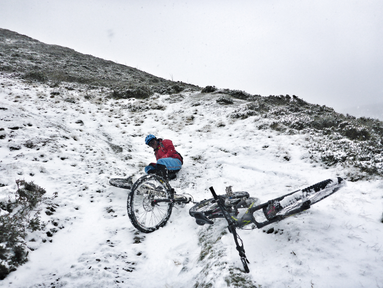 A cyclist takes a spill in the snow